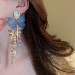 Detail of blue fabric butterfly tassel earrings with crystal beads and rhinestones