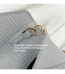 Detail aus silbernem Paillettenstoff und goldenen Metallringen für den Schultergurt der Tasche