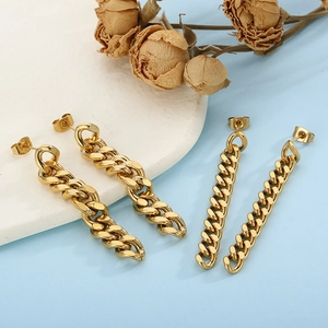 Detail of gold Cuban link earrings in two widths on a blue background