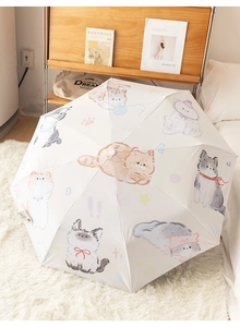 Detail of white automatic folding umbrella with cute cartoon cat illustrations on plush rug