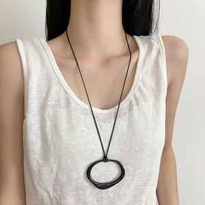 Minimalist black cord long necklace with irregular geometric oval pendant on model