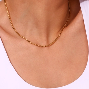 Detailed view of 18K gold plated stainless steel box chain necklace on model neck