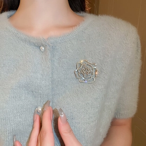 Detailed macro view of the silver hollow flower brooch with sparkling rhinestones on fabric