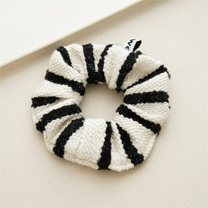 Macro shot of French style black and white striped tweed scrunchie with soft knit texture