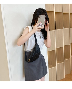 Detail of black quilted waist bag with metal zipper and adjustable nylon strap for women