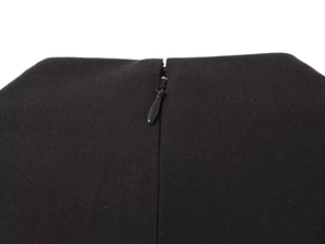 Close-up detail of invisible zipper on the back of a sleeveless black fashion top