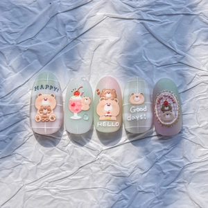 Detail of macaron-colored press-on nails with 3D bear relief and cherry patterns