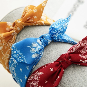 Close-up of knot detail on wide paisley print headbands in yellow, blue and burgundy colors