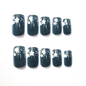 Dark blue glitter press-on nails with white flower and star patterns in 10-piece set