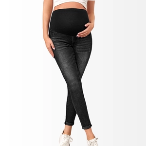 Detail of high-elastic black belly support band on maternity skinny denim jeans