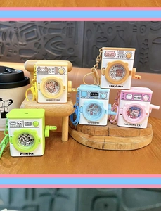 Detailed view of colorful cartoon washing machine keychains with cute animal designs.