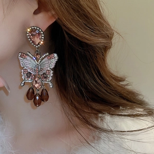 Macro view of crystal butterfly tassel earrings with pink drop stones and gradient wings