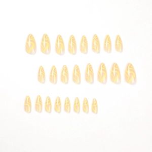 Yellow wave pattern press-on nails in long stiletto shape with translucent pink base