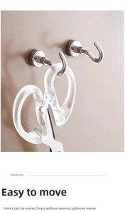 Macro shot of silver magnetic metal J-hook holding scissors on a wall for easy storage