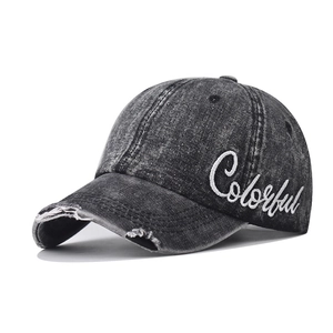 Close-up of distressed washed denim baseball cap with Colorful embroidery and frayed brim