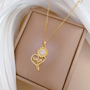 Macro view of golden sunflower heart pendant with white zircons on a jewelry box