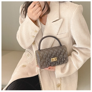 Detail of dark gray translucent jelly bag with quilted texture and gold chain strap