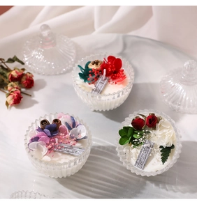 Detailed view of scented candles in glass jars with dried flowers and cinnamon sticks