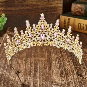 Elegant gold bridal crown with pink crystals and rhinestones on vintage wood background