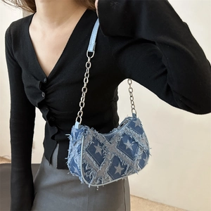 Blue denim crossbody bag with star pattern and chain strap shown on a model