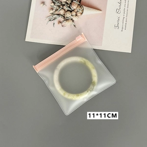 Detail of 11x11cm pink zip square jewelry storage bag with jade bracelet inside