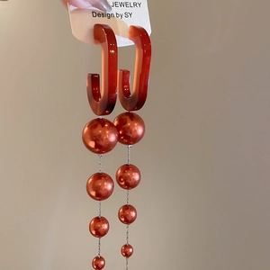 Detail showing amber U-shape resin and cascading gradient brown beads on fringe earrings
