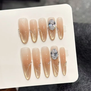 Detailansicht der handgefertigten Cat-Eye-Nägel mit Bernstein-Gradient und Strass-Akzenten