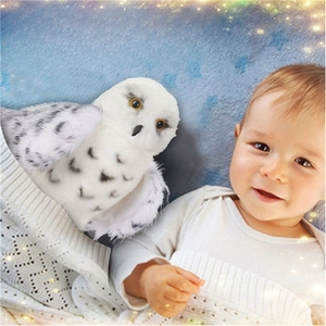 Adorable white snowy owl plush toy for babies on soft knit blanket with star background