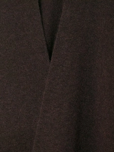Detailed macro view of deep brown knitted fabric texture and collar stitching on the poncho