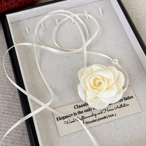 Elegant beige fabric rose choker with long ribbon ties and a pearl detail in a gift box