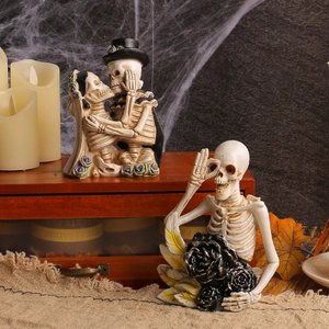 Halloween resin skeleton figurines including kissing couple and single skull with rose