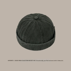 Detail of a dark gray washed cotton brimless docker hat with vintage stitching and texture
