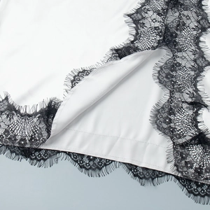 Vue détaillée du tissu en soie blanche avec bordure en dentelle de cils noire exquise
