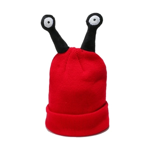 Close-up of funny red knitted beanie with unique black snail eye antennae details