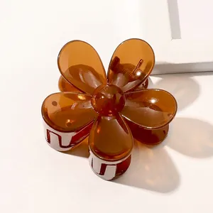 Detail view of a translucent dark brown flower hair claw clip with a glossy finish