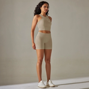 Close-up of seamless ribbed knit texture on beige yoga crop top and high-waist shorts set