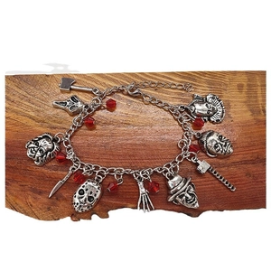 Bracelet d'horreur avec breloques en argent et perles rouges sur bloc de bois