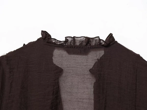 Detail of ruffle neck on dark coffee sheer fabric blouse with layered pleats