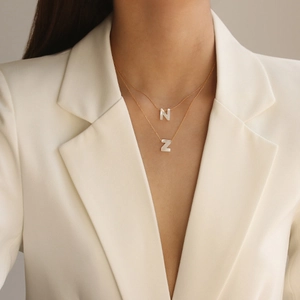 Vue détaillée du collier doré double rang avec pendentifs lettres N et Z nacrés