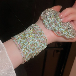 Close-up of mint green multi-layer wrap bracelet with shimmering crystals and silver accents