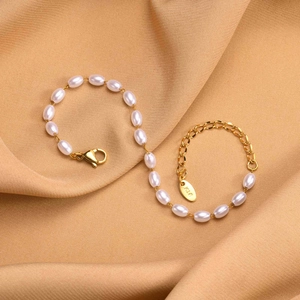 Detail eines 18K Gold-Perlenarmbands mit K18-Stempel auf warmem Seidenhintergrund