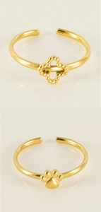 Detail of adjustable gold rings featuring open clover and paw print designs