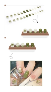 Dettagli di unghie finte verde oliva e crema con motivi a cuore e stile French manicure