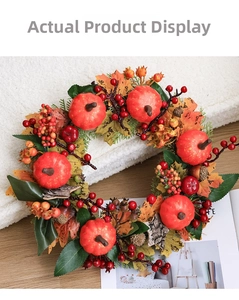Close-up of autumn wreath with pumpkins, red berries, pine cones and maple leaves