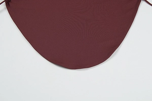 Detail of burgundy backless top featuring fine plain weave fabric and adjustable ties