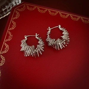 Macro shot of silver textured hoop earrings featuring unique metallic needle cluster design