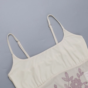 Détail des bretelles réglables et motif floral en strass violets sur haut en maille