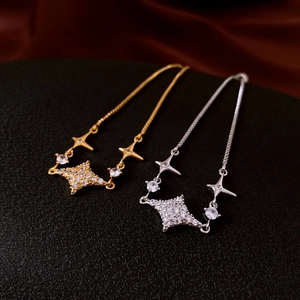 Vista macro di braccialetti regolabili in oro e argento con ciondoli stella in zircone