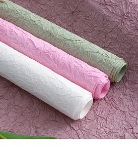 Detail showing the irregular wrinkled texture of white, pink, and green handmade paper