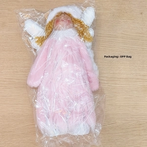 Détail de poupée ange de Noël en peluche avec manteau rose et fil d'argent brillant